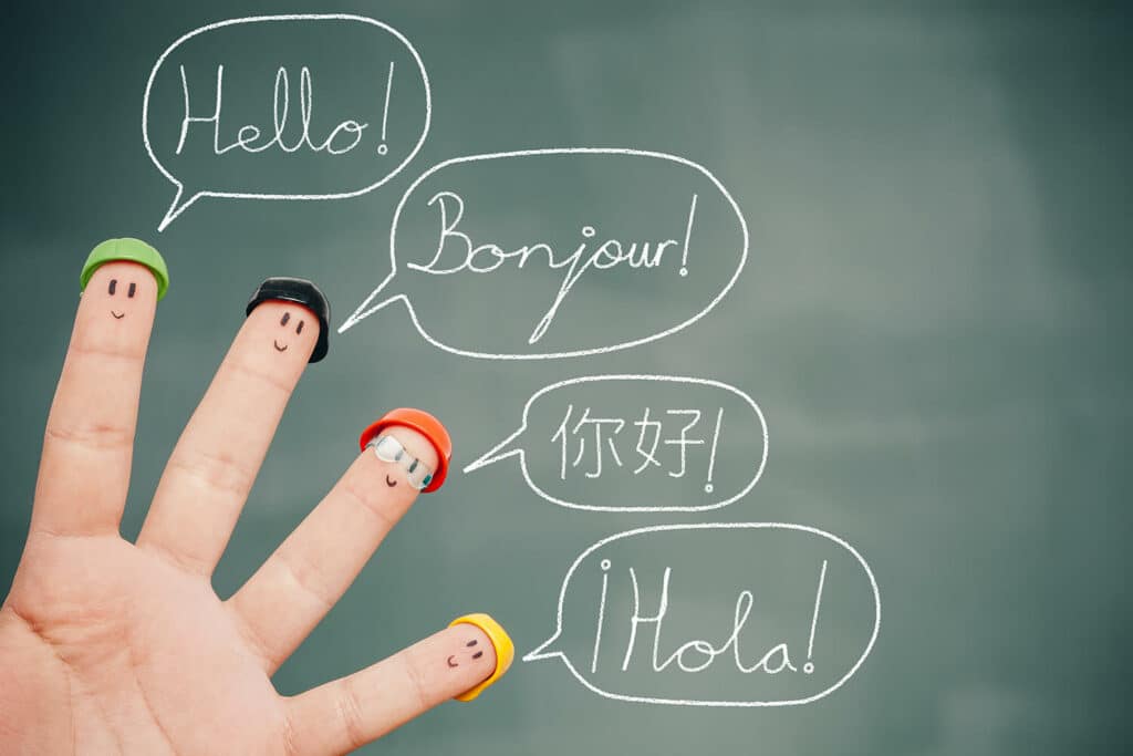 une main et le mot bonjour en 4 langues