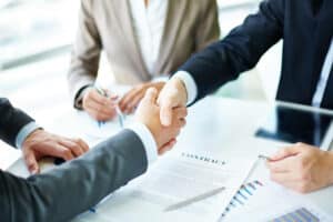 Deux hommes se serrant la main apres avoir signe un contrat