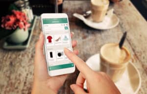femme regardant des fiches produits ecommerce sur son telephone portable