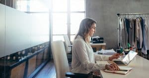 femme devant son bureau faisant du ecommerce - et remplissant les documents clés obligatoires