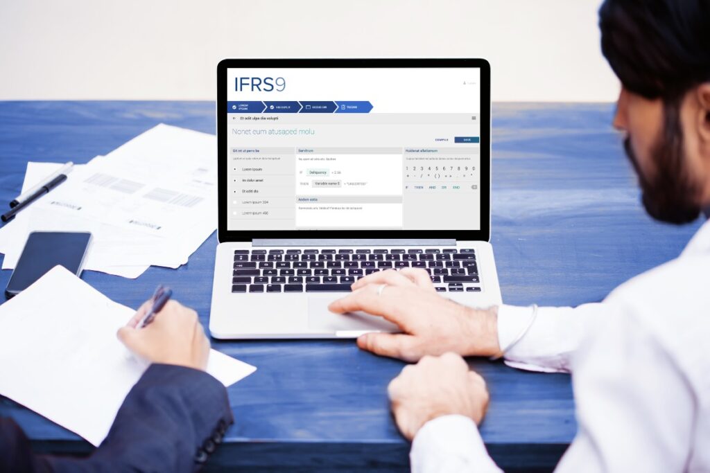 Application IFRS 9 ouverte sur ordinateur portable devant deux employés de banque